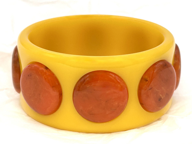 Brandon mellow yellow bakelite bangle with raised marbled orange bakelite dots