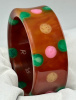AP15 red tea bakelite bangle with pink, green and butter dots