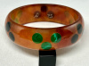AP16 red tea bakelite bangle with green and black dots